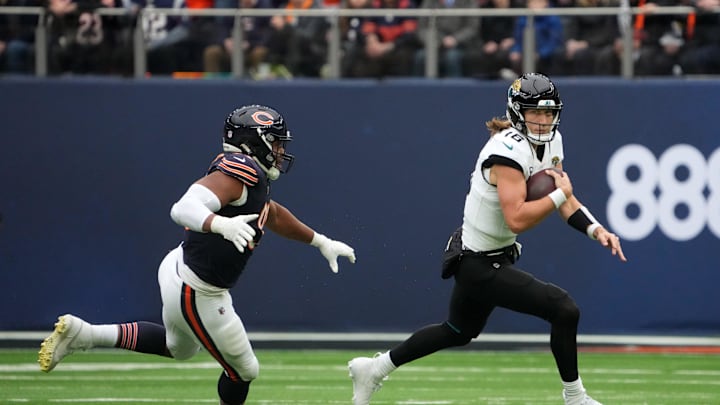 Oct 13, 2024; London, United Kingdom; Jacksonville Jaguars quarterback Trevor Lawrence (16) carries the ball against Chicago Bears defensive end DeMarcus Walker (95) in the first half during an NFL International Series game at Tottenham Hotspur Stadium. Mandatory Credit: Kirby Lee-Imagn Images