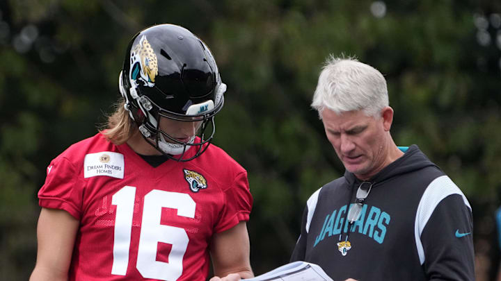 Oct 16, 2024; Watford, United Kingdom; Jacksonville Jaguars quarterbacks coach Mike McCoy (right) with quarterback Trevor Lawrence during practice at The Grove. Mandatory Credit: Kirby Lee-Imagn Images