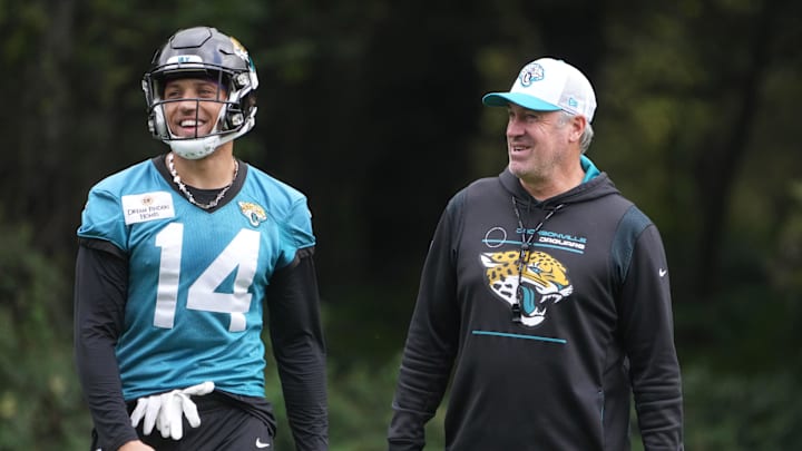 Oct 16, 2024; Watford, United Kingdom; Jacksonville Jaguars coach Doug Pederson (right) interacts with wide receiver Elijah Cooks (14) during practice at The Grove. Mandatory Credit: Kirby Lee-Imagn Images