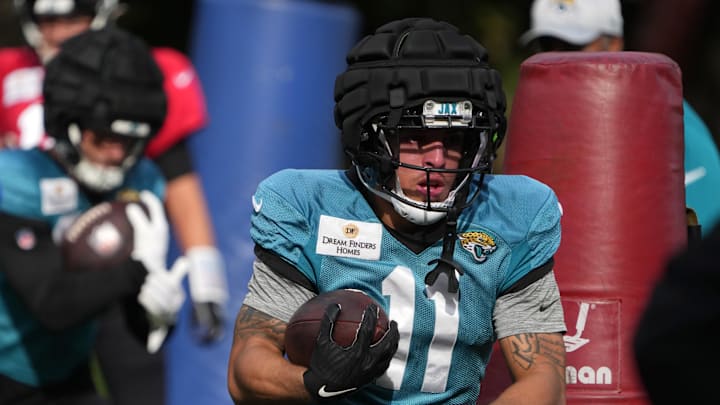 Oct 17, 2024; Watford, United Kingdom; Jacksonville Jaguars wide receiver Parker Washington (11) carries the ball wearing a Guardian helmet cap during practice at The Grove. Mandatory Credit: Kirby Lee-Imagn Images