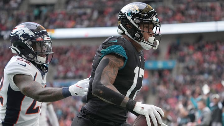 Oct 30, 2022; London, United Kingdom; Jacksonville Jaguars tight end Evan Engram (17) catches a touchdown pass as Denver Broncos safety Kareem Jackson (22) defends in the first quarter during an NFL International Series game at Wembley Stadium. Mandatory Credit: Kirby Lee-Imagn Images