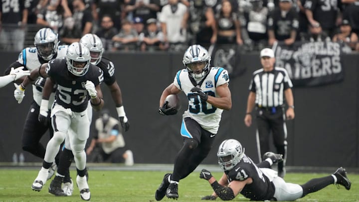 Sep 22, 2024; Paradise, Nevada, USA; Carolina Panthers running back Chuba Hubbard (30) carries the ball against Las Vegas Raiders linebacker Amari Gainer (53) in the first half at Allegiant Stadium. Mandatory Credit: Kirby Lee-Imagn Images