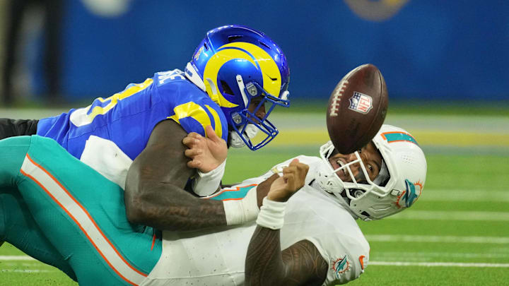 Nov 11, 2024; Inglewood, California, USA; Los Angeles Rams linebacker Jared Verse (8) forces a fumble by Miami Dolphins quarterback Tua Tagovailoa (1) in the first half at SoFi Stadium. Mandatory Credit: Kirby Lee-Imagn Images
