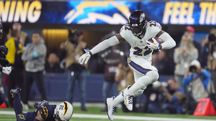 Nov 25, 2024; Inglewood, California, USA; Baltimore Ravens running back Derrick Henry (22) carries the ball against  cornerback Elijah Molden (22) in the second half at SoFi Stadium. Mandatory Credit: Kirby Lee-Imagn Images