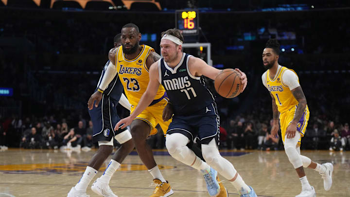 Dallas Mavericks guard Luka Doncic (77) dribbles the ball against Los Angeles Lakers forward LeBron James.