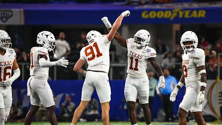Texas Longhorns edge rushers Colin Simmons (11) and Ethan Burke (91) celebrate a sack during the College Football Playoff semifinal game against Ohio State in the Cotton Bowl at AT&T Stadium on Friday, Jan. 10, 2024 in Arlington, Texas.