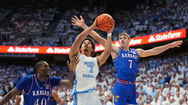 Nov 7, 2025; Chapel Hill, North Carolina, USA;  North Carolina Tar Heels guard Seth Trimble (7) shoots as Kansas Jayhawks forward Flory Bidunga (40) and guard Kohl Rosario (7) defend in the second half at Dean E. Smith Center. Mandatory Credit: Bob Donnan-Imagn Images