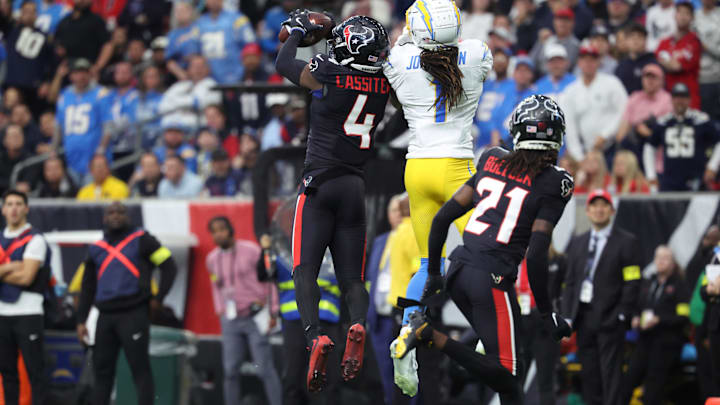 Jan 11, 2025; Houston, Texas, USA; Houston Texans corner back Kamari Lassiter (4) intercepts a pass for Los Angeles Chargers wide receiver Quentin Johnston (1) during the second quarter in an AFC wild card game at NRG Stadium. Mandatory Credit: Troy Taormina-Imagn Images