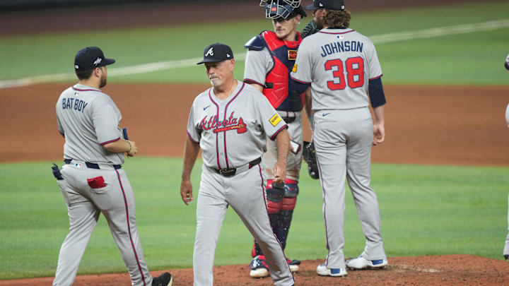Jun 20, 2025; Miami, Florida, USA;  Atlanta Braves manager Brian Snitker, second from left, puts in pitcher Pierce Johnson (38) in the seventh inning against the Miami Marlins at loanDepot Park. Mandatory Credit: Jim Rassol-Imagn Images