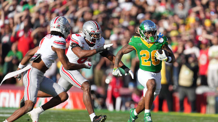 Jan 1, 2025; Pasadena, California, USA; Oregon Ducks running back Jordan James (20) carries the ball against Ohio State Buckeyes safety Sonny Styles (6) and cornerback Davison Igbinosun (1) during a CFP quarterfinal at Rose Bowl Stadium. Mandatory Credit: Kirby Lee-Imagn Images
