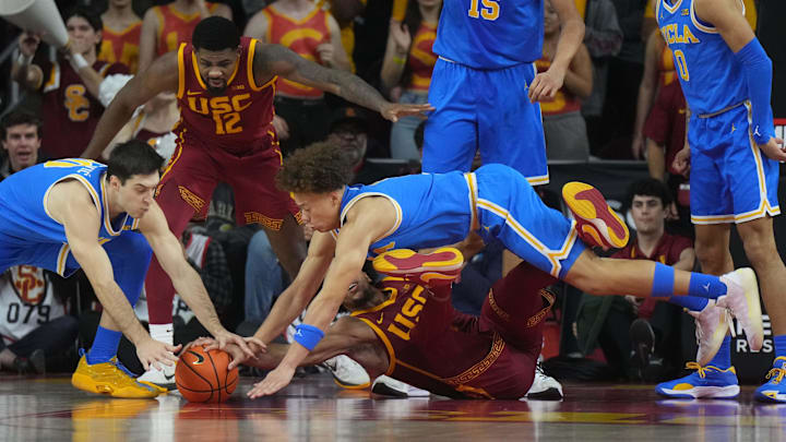 UCLA Bruins guard Trent Perry (1) and guard Lazar Stefanovic (10) battle for the ball with Southern California Trojans guard Desmond Claude (1) in the first half at Galen Center.