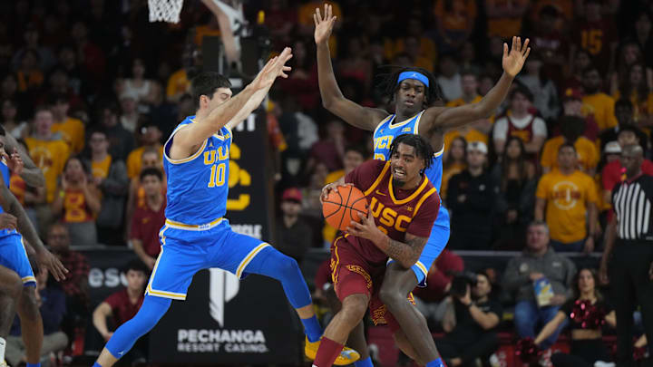 Southern California Trojans forward Saint Thomas is defended by UCLA Bruins guard Lazar Stefanovic and forward William Kyle III.