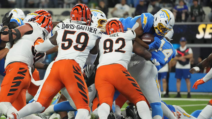 Nov 17, 2024; Inglewood, California, USA; Los Angeles Chargers running back J.K. Dobbins (27) scores on a 1-yard touchdown run against Cincinnati Bengals linebacker Akeem Davis-Gaither (59) and defensive tackle B.J. Hill (92) in the first half at SoFi Stadium. Mandatory Credit: Kirby Lee-Imagn Images