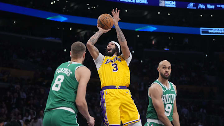 Jan 23, 2025; Los Angeles, California, USA; Los Angeles Lakers forward Anthony Davis (3) shoots the ball against Boston Celtics center Kristaps Porzingis (8) and guard Derrick White (9) in the second half at the Crypto.com Arena. Mandatory Credit: Kirby Lee-Imagn Images