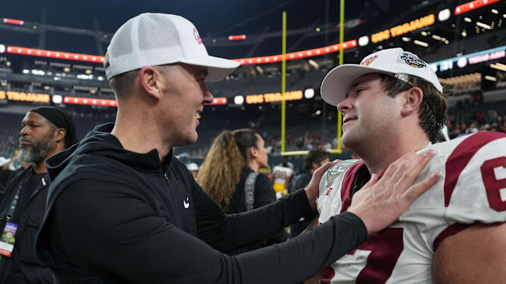 Dec 27, 2024; Las Vegas, NV, USA; Southern California Trojans head coach Lincoln Riley embraces offensive lineman Kilian O'Connor (67) after the game against the Texas A&M Aggies at Allegiant Stadium. Mandatory Credit: Kirby Lee-Imagn Images Dec 27, 2024; Las Vegas, NV, USA; Southern California Trojans head coach Lincoln Riley embraces offensive lineman Kilian O'Connor (67) after the game against the Texas A&M Aggies at Allegiant Stadium. Mandatory Credit: Kirby Lee-Imagn Images
