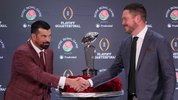 Dec 31, 2024; Los Angeles, California, USA; Ohio State Buckeyes head coach Ryan Day (left) and Oregon Ducks head coach Dan Lanning shake hands with the Leishman Trophy as a backdrop during the Rose Bowl head coaches press conference at Sheraton Grand LA. Mandatory Credit: Kirby Lee-Imagn Images