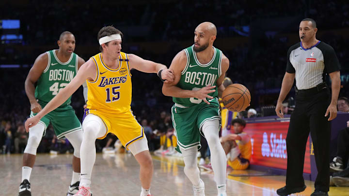 Jan 23, 2025; Los Angeles, California, USA; Boston Celtics guard Derrick White (9) dribbles the ball against Los Angeles Lakers guard Austin Reaves (15)  in the first half at Crypto.com Arena. Mandatory Credit: Kirby Lee-Imagn Images