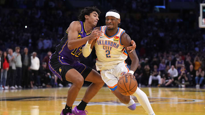 Nov 29, 2024; Los Angeles, California, USA; Oklahoma City Thunder guard Shai Gilgeous-Alexander (2) dribbles against Los Angeles Lakers guard Austin Reaves (15) in the second half at Crypto.com Arena. Mandatory Credit: Kirby Lee-Imagn Images