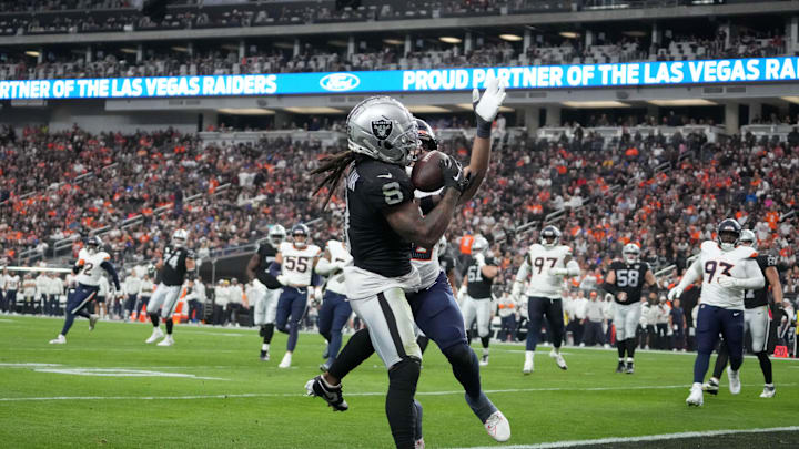 Nov 24, 2024; Paradise, Nevada, USA; Las Vegas Raiders running back Ameer Abdullah (8) scores on a 6-yard touchdown reception against Denver Broncos linebacker Jonah Elliss (52) in the second quarter at Allegiant Stadium. Mandatory Credit: Kirby Lee-Imagn Images