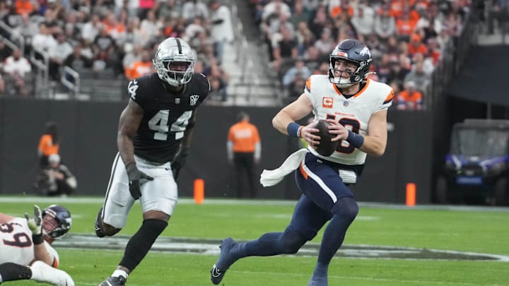 Nov 24, 2024; Paradise, Nevada, USA; Denver Broncos quarterback Bo Nix (10) carries the ball against Las Vegas Raiders defensive end K'Lavon Chaisson (44) in the second quarter at Allegiant Stadium. Mandatory Credit: Kirby Lee-Imagn Images