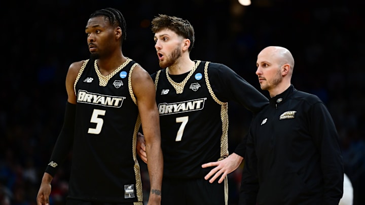 Mar 21, 2025; Cleveland, OH, USA; Bryant University Bulldogs forward Barry Evans (5) forward Connor Withers (7) and head coach Phil Martelli Jr reacts in the second half against the Michigan State Spartans  during the NCAA Tournament First Round at Rocket Mortgage Fieldhouse. Mandatory Credit: Ken Blaze-Imagn Images
