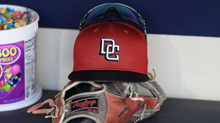 Jul 12, 2024; Milwaukee, Wisconsin, USA;  An Washington Nationals hat and glove sit in the dugout during batting practice prior to the game against the Milwaukee Brewers at American Family Field.