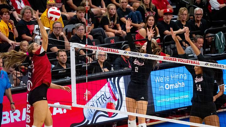 Oct 10, 2026; Lincoln, Nebraska, USA;  Wisconsin Badgers middle blocker Lynney Tarnow (20) attacks against Nebraska Cornhuskers setter Bergen Reilly (2) and middle blocker Manaia Ogbechie (14) during the first set at Bob Devaney Sport Center.  Mandatory Credit: Dylan Widger-Imagn Images