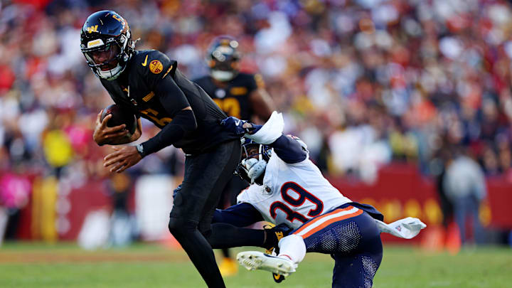 Oct 27, 2024; Landover, Maryland, USA; Chicago Bears cornerback Josh Blackwell (39) tackles Washington Commanders quarterback Jayden Daniels (5) during the second quarter at Commanders Field. Mandatory Credit: Peter Casey-Imagn Images