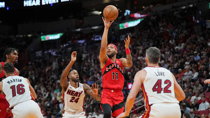 Apr 12, 2024; Miami, Florida, USA;  Toronto Raptors forward Bruce Brown (11) lobs a pass toward the basket as Miami Heat forward Haywood Highsmith (24) and forward Kevin Love (42) defend during the second half at Kaseya Center. Mandatory Credit: Jim Rassol-Imagn Images