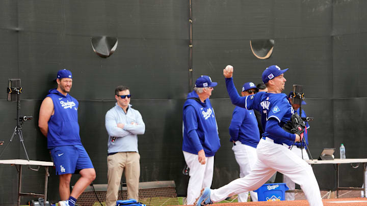 Feb 12, 2025; Glendale, AZ, USA; Los Angeles Dodgers pitcher Blake Snell (7) throws as pitcher Clayton Kershaw (left) looks on during a Spring Training workout at Camelback Ranch. Mandatory Credit: Joe Camporeale-Imagn Images