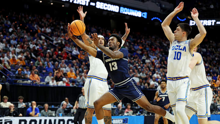 Mar 20, 2025; Lexington, KY, USA;  Utah State Aggies guard Deyton Albury (13) shoots the ball against UCLA Bruins guard Lazar Stefanovic (10) during the first half in the first round of the NCAA Tournament at Rupp Arena. Mandatory Credit: Jordan Prather-Imagn Images
