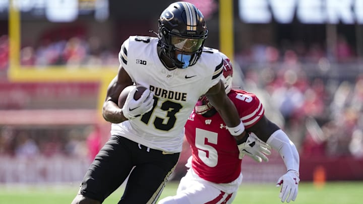 Oct 5, 2024; Madison, Wisconsin, USA; Purdue Boilermakers wide receiver Jaron Tibbs (13) rushes with the football in front of Wisconsin Badgers cornerback RJ Delancy III (5) during the second quarter at Camp Randall Stadium. Mandatory Credit: Jeff Hanisch-Imagn Images Oct 5, 2024; Madison, Wisconsin, USA; Purdue Boilermakers wide receiver Jaron Tibbs (13) rushes with the football in front of Wisconsin Badgers cornerback RJ Delancy III (5) during the second quarter at Camp Randall Stadium. Mandatory Credit: Jeff Hanisch-Imagn Images
