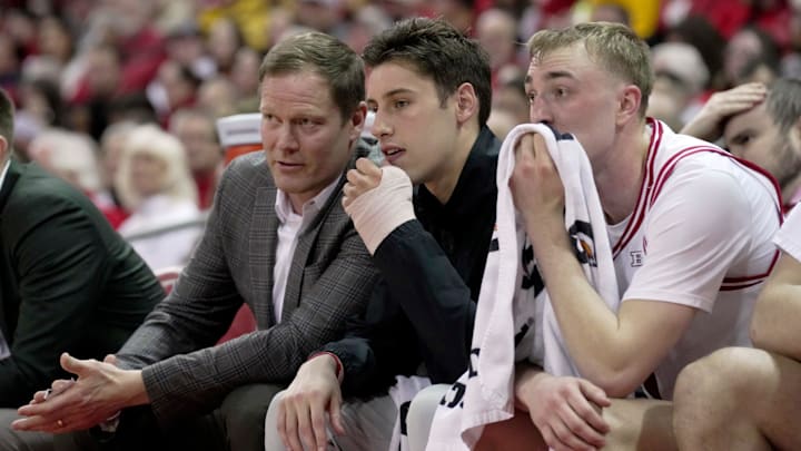 Injured Wisconsin guard Jack Janicki (5) listens to associate head coach Joe Krabbenhoft, left, during the first half of the game Sunday, February 22, 2026 at the Kohl Center in Madison, Wisconsin.