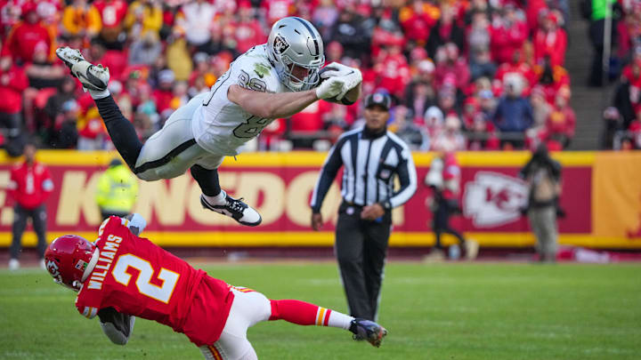 Nov 29, 2024; Kansas City, Missouri, USA; Las Vegas Raiders tight end Brock Bowers (89) leaps with the ball as Kansas City Chiefs cornerback Joshua Williams (2) defends during the first half at GEHA Field at Arrowhead Stadium. Mandatory Credit: Denny Medley-Imagn Images