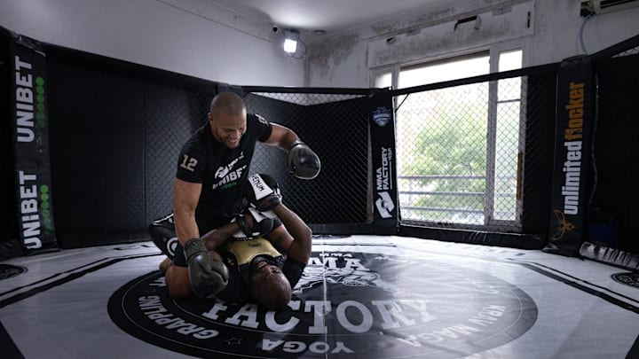 Two fighters train at an MMA gym