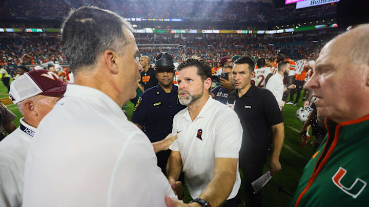 Sep 27, 2024; Miami Gardens, Florida, USA; Virginia Tech Hokies head coach Brent Pry shakes hands with Miami Hurricanes head coach Mario Cristobal after the game at Hard Rock Stadium. Mandatory Credit: Sam Navarro-Imagn Images