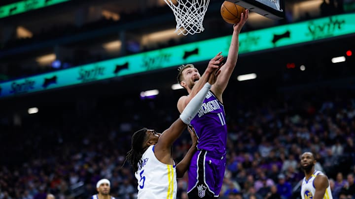 Jan 22, 2025; Sacramento, California, USA; Sacramento Kings forward Domantas Sabonis (11) drives to the basket against Golden State Warriors forward Kevon Looney (5) during the first quarter at Golden 1 Center. Mandatory Credit: Sergio Estrada-Imagn Images