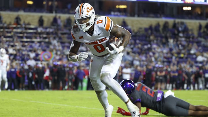 Oklahoma State Cowboys running back Ollie Gordon II scores a touchdown past TCU Horned Frogs safety Jamel Johnson during the second half at Amon G. Carter Stadium last season.