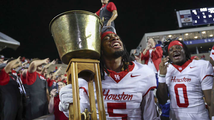 Sep 6, 2025; Houston, Texas, USA; Houston Cougars wide receiver Stephon Johnson (5) holds the Bayou Bucket trophy after a win against the Rice Owls at Rice Stadium. 