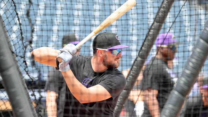 Colorado Rockies designated hitter Kris Bryant prepares to swing a bat while wearing a black T-shirt and hat