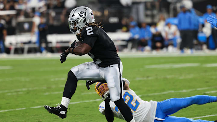 Sep 15, 2025; Paradise, Nevada, USA;  Las Vegas Raiders running back Ashton Jeanty (2) evades a tackle from Los Angeles Chargers safety Alohi Gilman (32) during the first quarter at Allegiant Stadium. Mandatory Credit: Kiyoshi Mio-Imagn Images