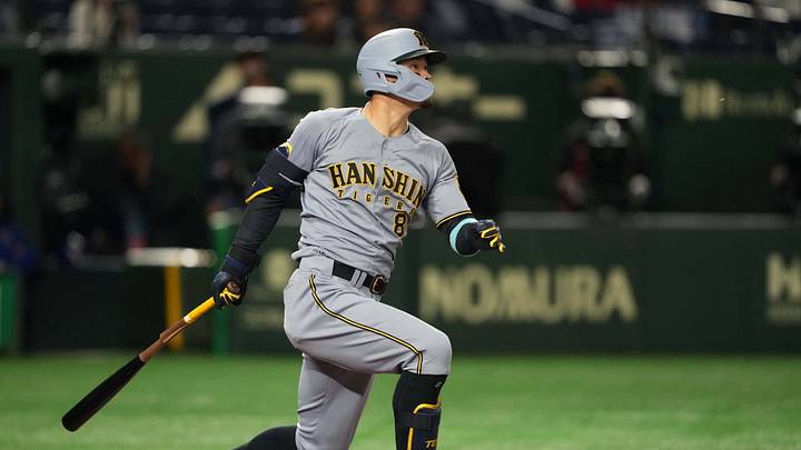 Mar 15, 2025; Bunkyo, Tokyo, Japan; Hanshin Tigers right fielder Teruaki Sato (8) hits an RBI single against the Chicago Cubs during the fifth inning at Tokyo Dome. Mandatory Credit: Darren Yamashita-Imagn Images