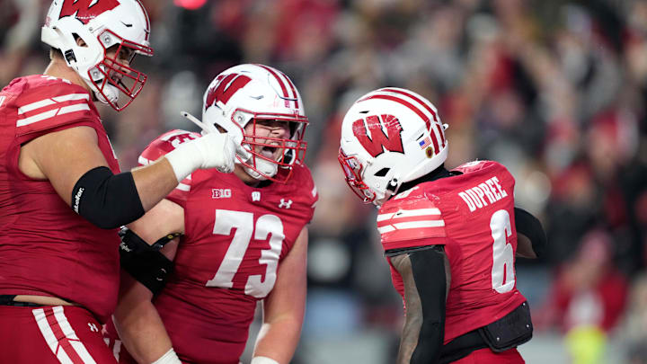 Nov 22, 2025; Madison, Wisconsin, USA; Wisconsin Badgers offensive lineman Riley Mahlman, left, and Wisconsin Badgers offensive lineman Kerry Kodanko (73) react to a touchdown scored by Wisconsin Badgers running back Darrion Dupree (6) during the second half against the Illinois Fighting Illini at Camp Randall Stadium. Nov 22, 2025; Madison, Wisconsin, USA; Wisconsin Badgers offensive lineman Riley Mahlman, left, and Wisconsin Badgers offensive lineman Kerry Kodanko (73) react to a touchdown scored by Wisconsin Badgers running back Darrion Dupree (6) during the second half against the Illinois Fighting Illini at Camp Randall Stadium.