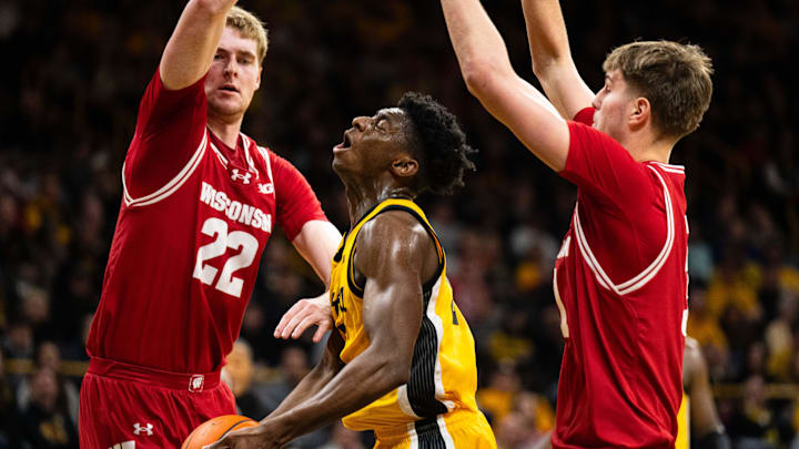 Feb 8, 2025; Iowa City, Iowa, USA; Iowa Hawkeyes guard Drew Thelwell (3) goes down against Wisconsin Badgers forward Steven Crowl (22) and forward Nolan Winter (31) during the second half at Carver-Hawkeye Arena. Mandatory Credit: Dylan Widger-Imagn Images