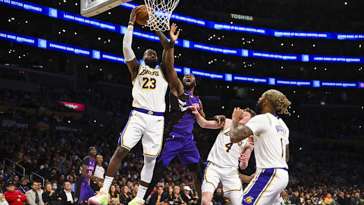 Nov 10, 2024; Los Angeles, California, USA; Los Angeles Lakers forward LeBron James (23) grabs the rebound against Toronto Raptors forward Bruno Fernando (24) during the second half at Crypto.com Arena. Mandatory Credit: Jonathan Hui-Imagn Images