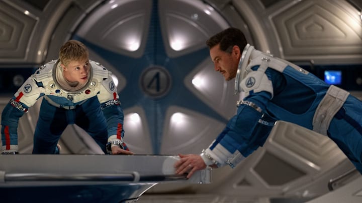 (L-R) Joseph Quinn as Johnny Storm/Human Torch and Pedro Pascal as Reed Richards/Mister Fantasticin 20th Century Studios/Marvel Studios' THE FANTASTIC FOUR: FIRST STEPS. Photo courtesy of 20th Century Studios/Marvel Studios. © 2025 20th Century Studios / © and ™ 2025 MARVEL.