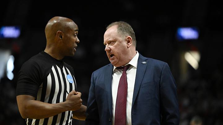 Mar 19, 2026; Portland, OR, USA; Wisconsin Badgers head coach Greg Gard talks with an official during the second half of a first round game of the men's 2026 NCAA Tournament against the High Point Panthers at Moda Center. Mandatory Credit: Troy Wayrynen-Imagn Images