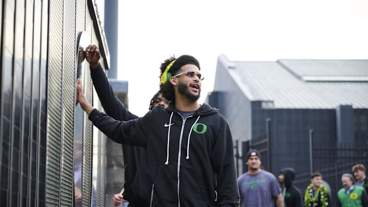 Nov 14, 2025; Eugene, Oregon, USA; Oregon Ducks quarterback Dante Moore (5) swipes his hand over the letter “O” during the “March to Victory” team walk before a game against the Minnesota Golden Gophers at Autzen Stadium. Mandatory Credit: Troy Wayrynen-Imagn Images