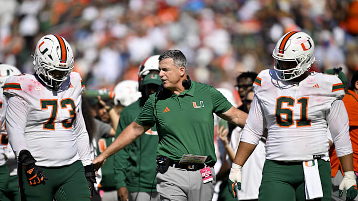 Nov 1, 2025; Dallas, Texas, USA; Miami Hurricanes head coach Mario Cristobal talks to offensive lineman Anez Cooper (73) and offensive lineman Francis Mauigoa (61) during the second half against the SMU Mustangs at Gerald J. Ford Stadium. Mandatory Credit: Jerome Miron-Imagn Images Nov 1, 2025; Dallas, Texas, USA; Miami Hurricanes head coach Mario Cristobal talks to offensive lineman Anez Cooper (73) and offensive lineman Francis Mauigoa (61) during the second half against the SMU Mustangs at Gerald J. Ford Stadium. Mandatory Credit: Jerome Miron-Imagn Images