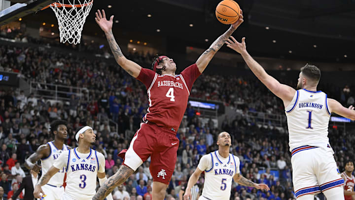 Mar 20, 2025; Providence, RI, USA;  Arkansas Razorbacks forward Trevon Brazile (4) reaches for the ball against Kansas Jayhawks center Hunter Dickinson (1) during the second half at Amica Mutual Pavilion. Mandatory Credit: Eric Canha-Imagn Images